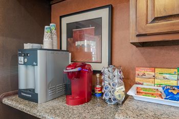 Kitchen counter with toaster, a red soda dispenser, and pack of chips